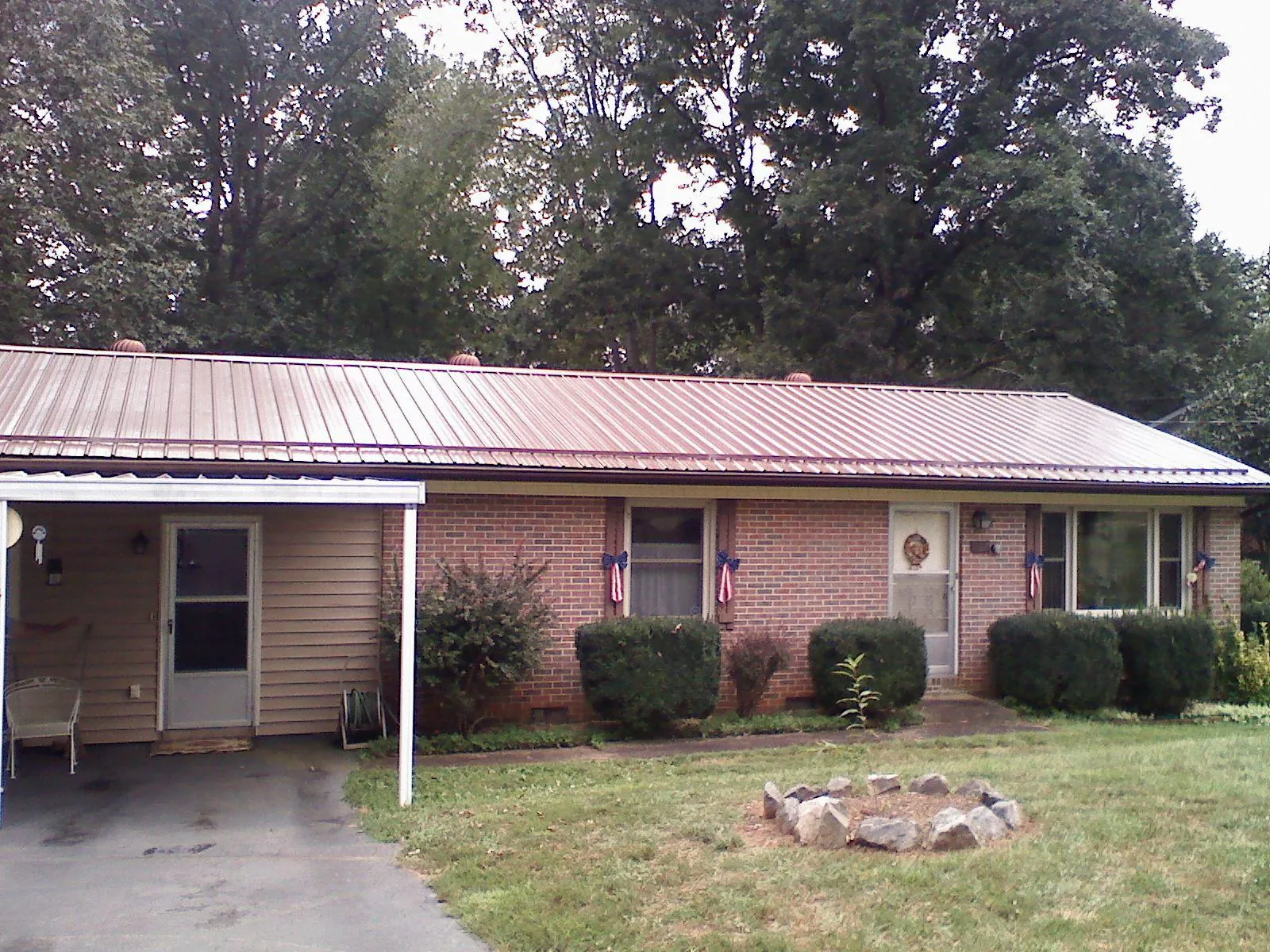 Bronze metal roof and carport on a brick ranch home — Roof Repair work by our crew in Sharps Chapel