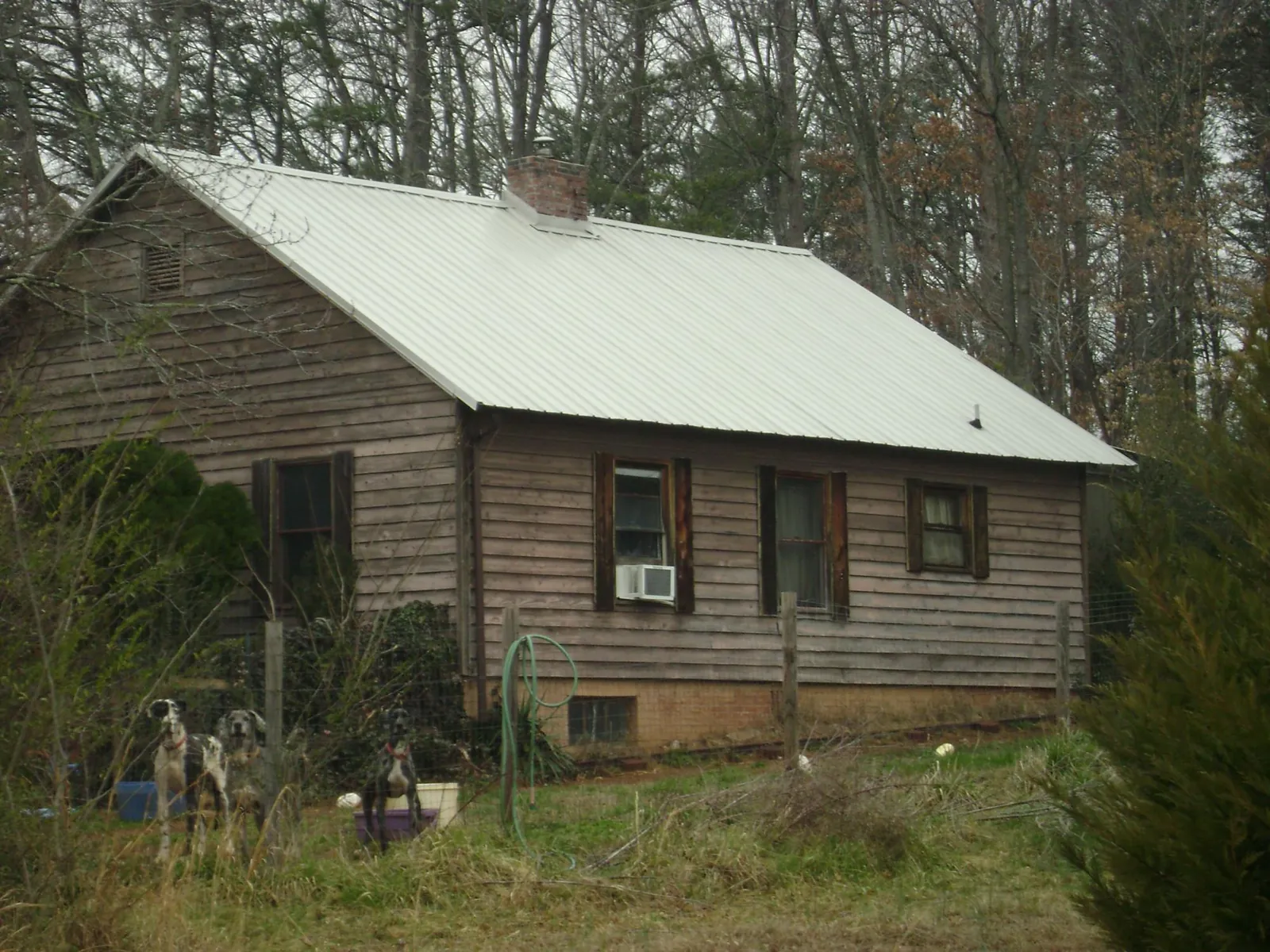 White metal roof on an old wood sided farmhouse, from a Metal Roof Installation job in Sharps Chapel